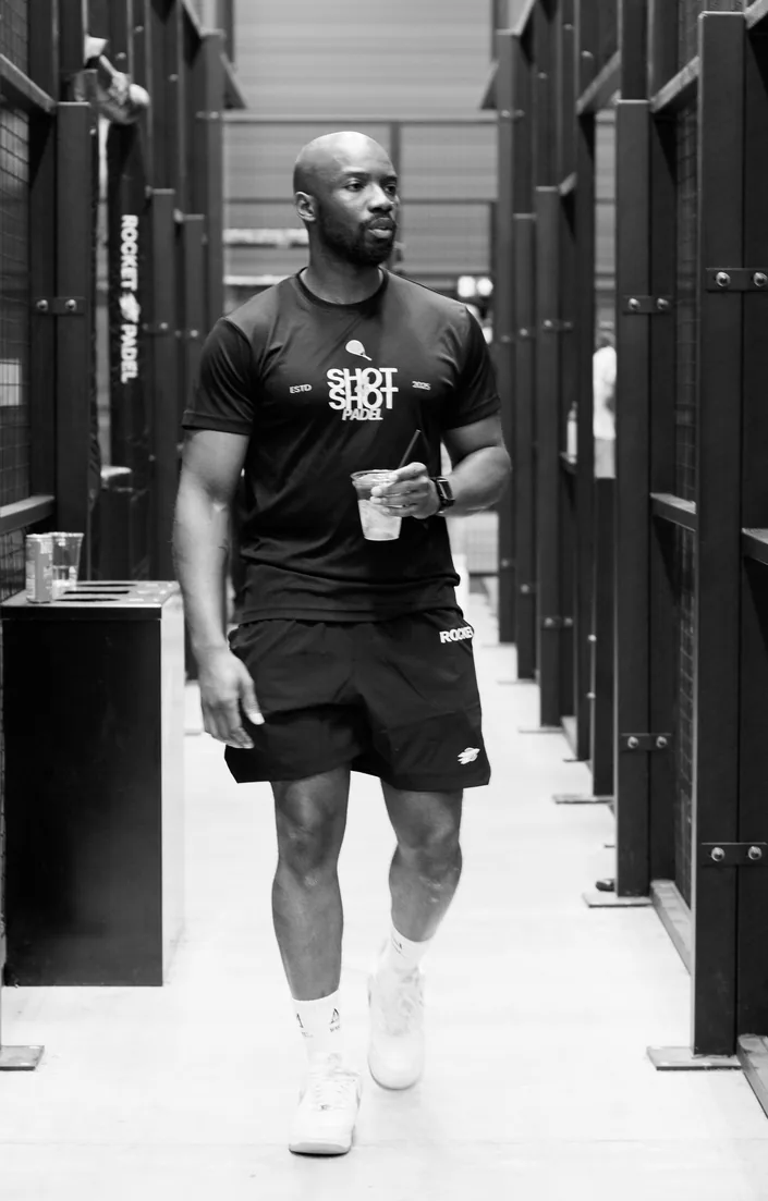 Lemzi — founder of Shot4Shot Padel — black and white performance shot
